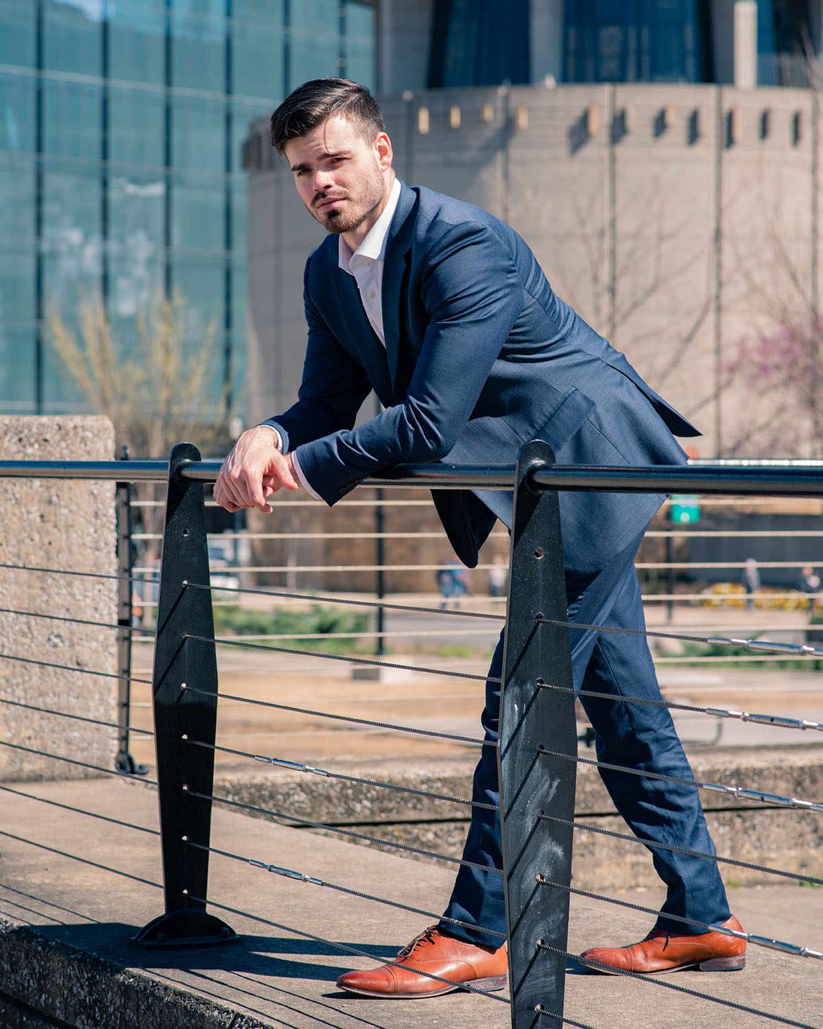 Joshua Nunley in a suit leaning on the fence